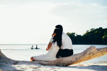 Majal and Regine Mirasol sitting at the beach. Honeymoon image.