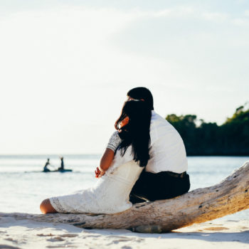 Majal and Regine Mirasol sitting at the beach. Honeymoon image.